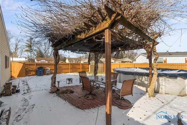 snow covered patio with a pergola and a covered pool