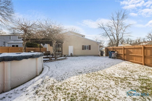 snow covered house featuring a covered pool