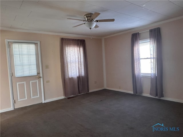 foyer entrance with ceiling fan, crown molding, and dark carpet