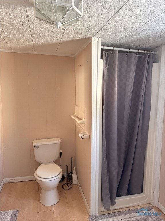 bathroom with a shower with shower curtain, wood-type flooring, and toilet