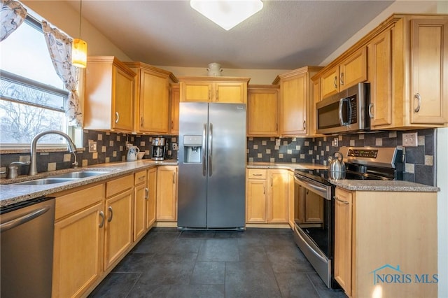 kitchen featuring stainless steel appliances, backsplash, hanging light fixtures, light stone counters, and sink