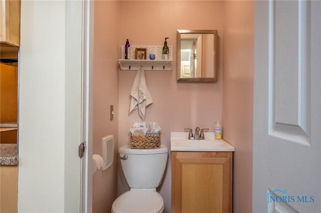 bathroom featuring toilet and vanity