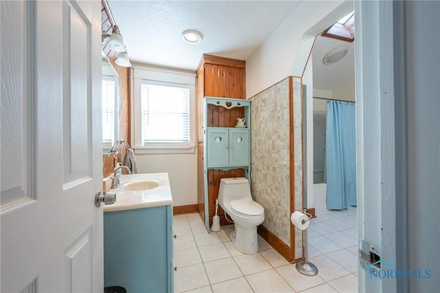 bathroom featuring toilet, vanity, tile patterned floors, a textured ceiling, and curtained shower