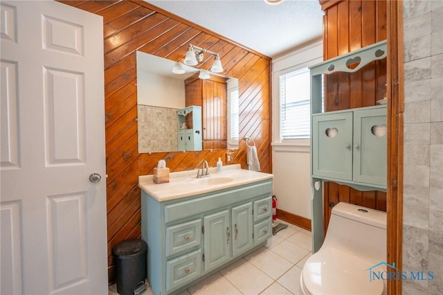 bathroom featuring toilet, vanity, tile patterned floors, and wooden walls