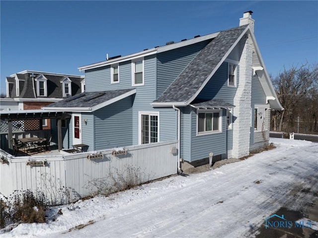 view of snow covered rear of property