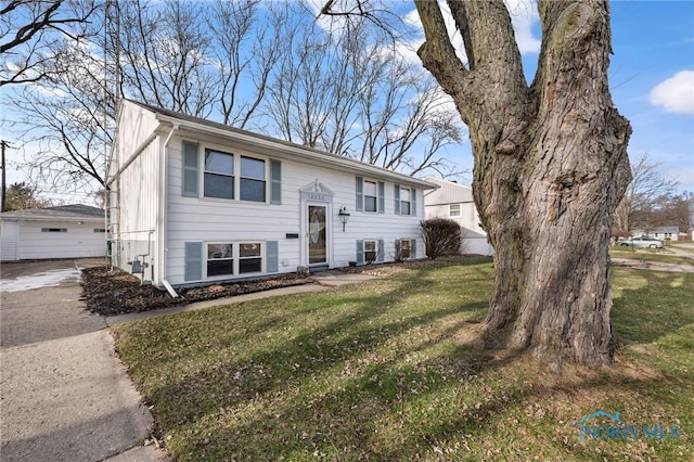 bi-level home featuring central AC unit and a front lawn