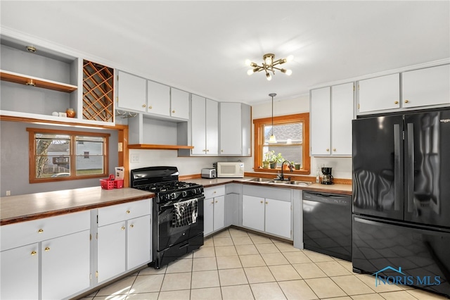 kitchen featuring pendant lighting, black appliances, sink, light tile patterned flooring, and white cabinetry