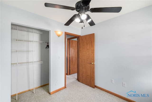 unfurnished bedroom with a closet, light colored carpet, and ceiling fan