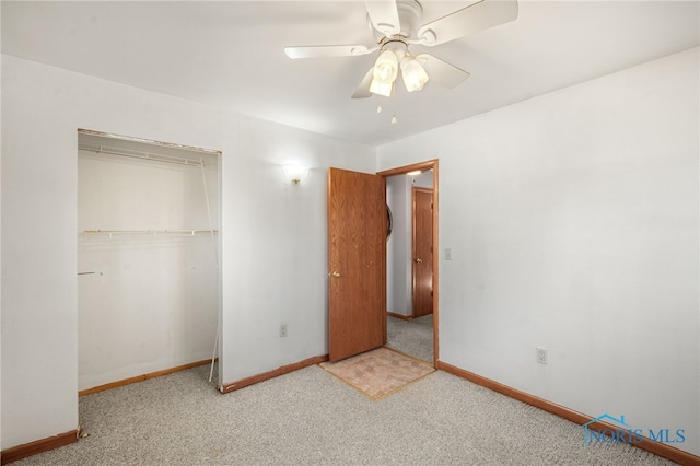 unfurnished bedroom featuring ceiling fan, a closet, and light colored carpet