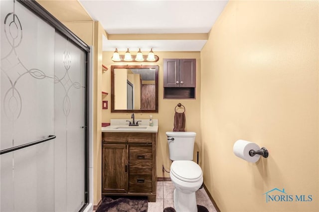 bathroom with tile patterned flooring, vanity, toilet, and walk in shower