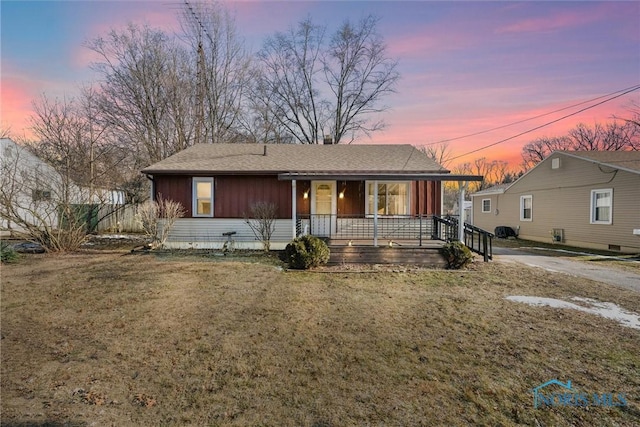 view of front of home featuring covered porch and a lawn