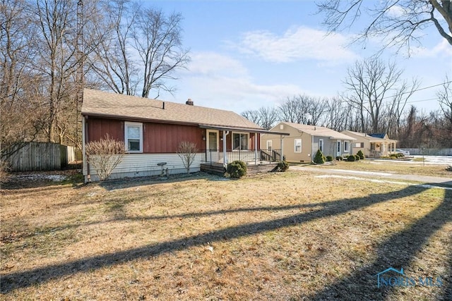 ranch-style house featuring covered porch and a front lawn