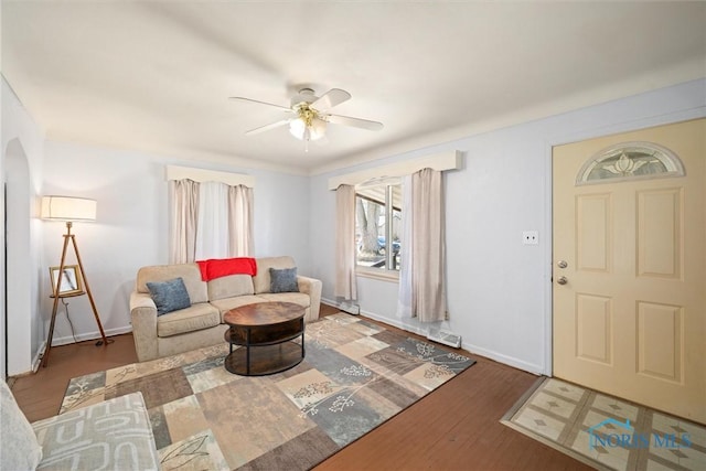 living room featuring ceiling fan and dark wood-type flooring