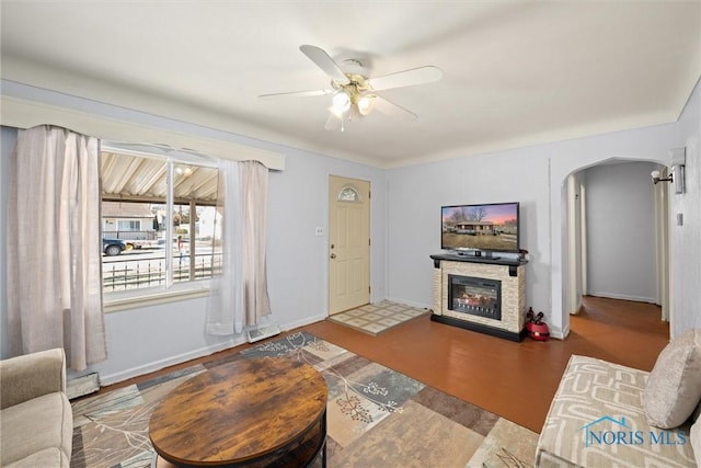 living room featuring ceiling fan, baseboard heating, and a fireplace