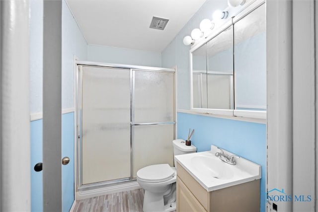 bathroom featuring vanity, hardwood / wood-style flooring, an enclosed shower, and toilet