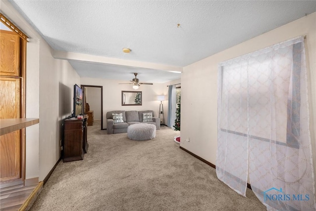 carpeted living room with ceiling fan and a textured ceiling