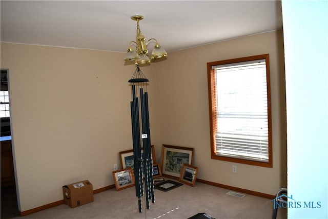 workout room with light colored carpet and an inviting chandelier