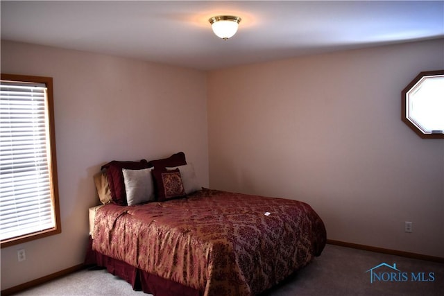 bedroom featuring light colored carpet and multiple windows