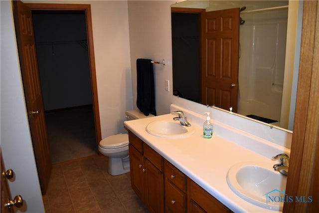 bathroom with tile patterned floors, walk in shower, vanity, and toilet