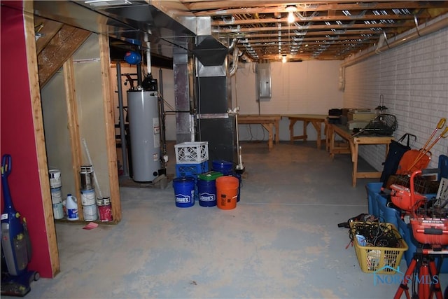 basement with brick wall, electric panel, heating unit, and water heater