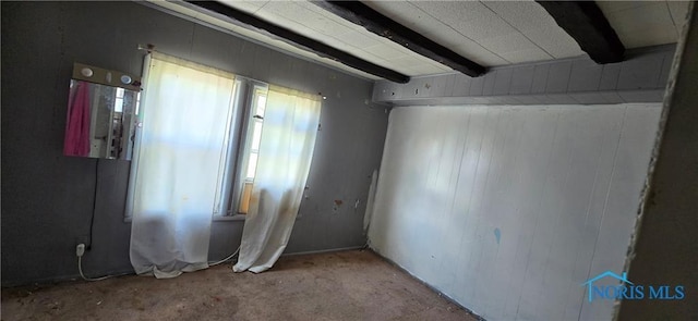 carpeted empty room with beamed ceiling and a wealth of natural light