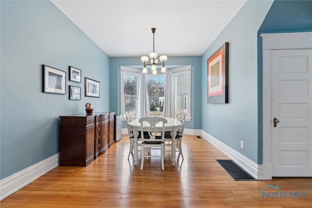 dining area featuring a chandelier and light hardwood / wood-style floors