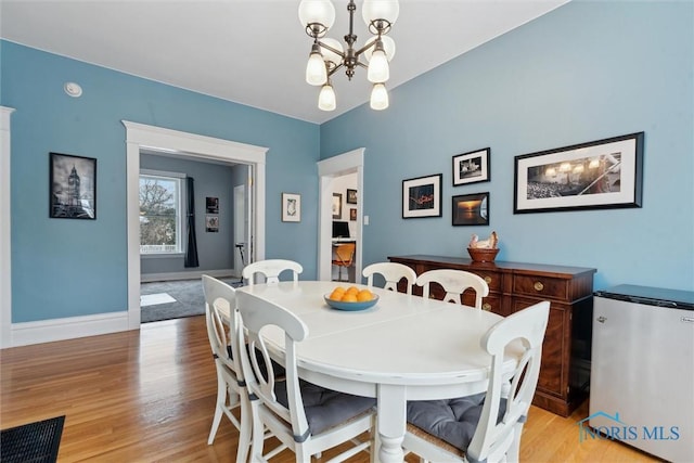 dining room with a notable chandelier and light wood-type flooring