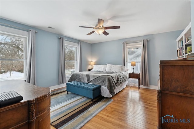 bedroom featuring multiple windows, ceiling fan, and light hardwood / wood-style floors