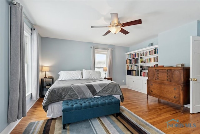 bedroom with light hardwood / wood-style floors and ceiling fan