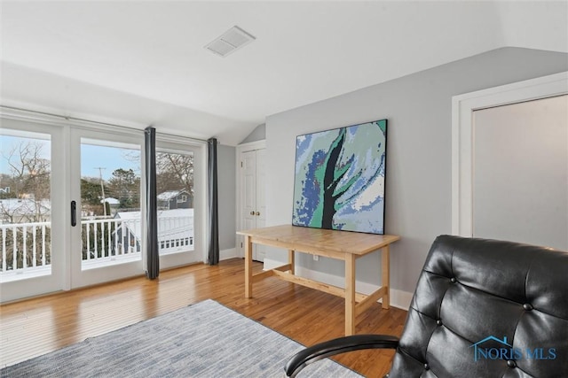 sitting room with hardwood / wood-style floors and vaulted ceiling