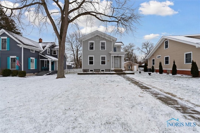 view of snow covered rear of property