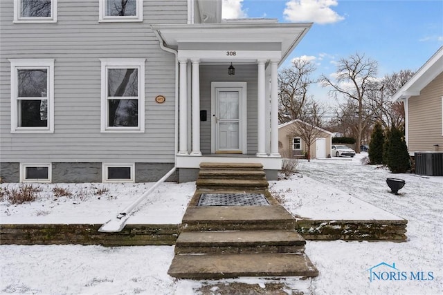 snow covered property entrance with central AC