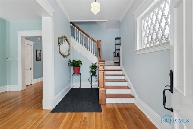 foyer with hardwood / wood-style floors and ornamental molding