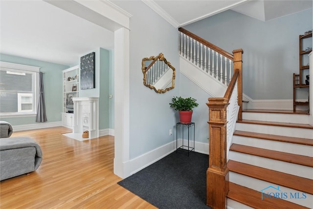 staircase featuring hardwood / wood-style floors and ornamental molding