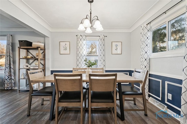 dining room featuring a notable chandelier, crown molding, and dark wood-type flooring