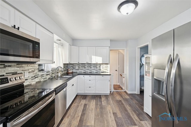 kitchen with decorative backsplash, dark hardwood / wood-style flooring, stainless steel appliances, sink, and white cabinetry