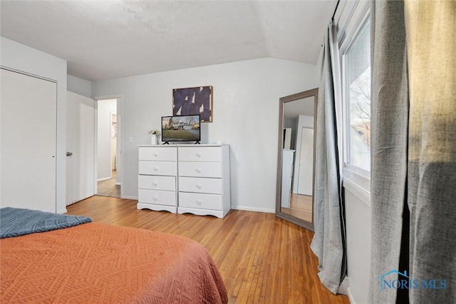 bedroom with light hardwood / wood-style floors and lofted ceiling