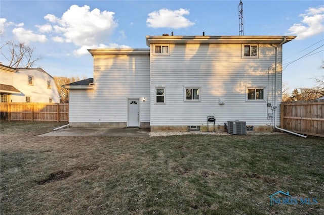 rear view of house featuring a lawn, cooling unit, and a patio