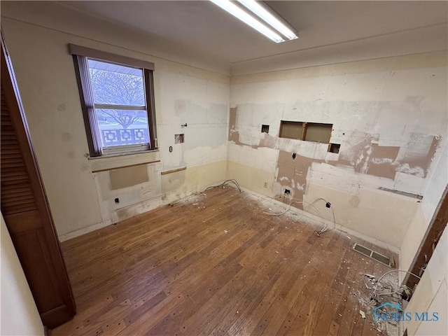 clothes washing area featuring hardwood / wood-style flooring