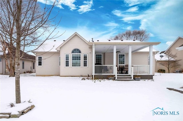 snow covered property with covered porch