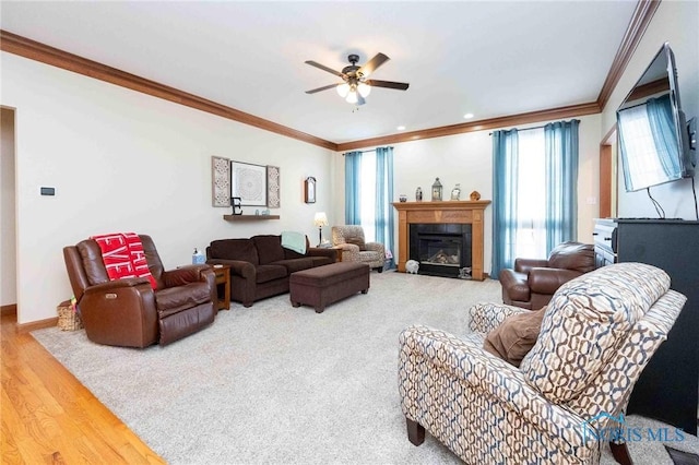 living room with wood-type flooring, crown molding, and a healthy amount of sunlight