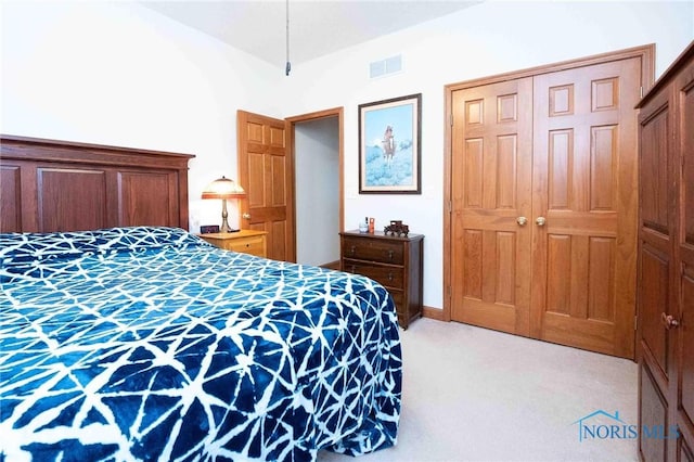 bedroom with light carpet and a closet