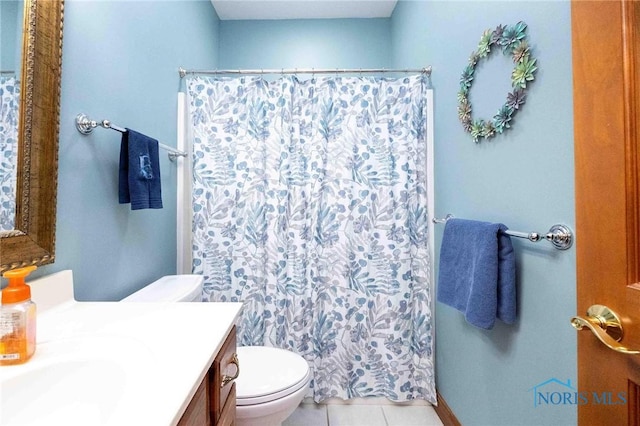 bathroom featuring tile patterned flooring, vanity, toilet, and curtained shower