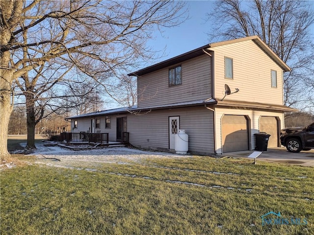 back of house featuring a garage and a yard