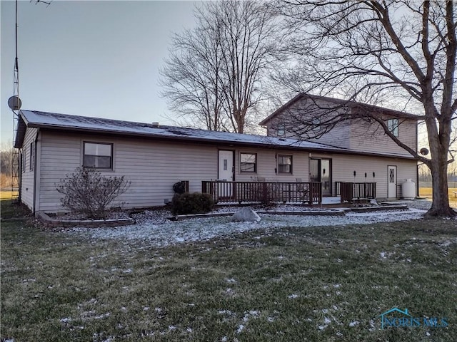 rear view of house with a yard and a wooden deck