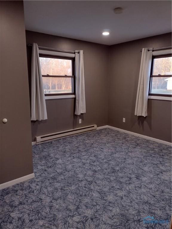 carpeted empty room with baseboard heating