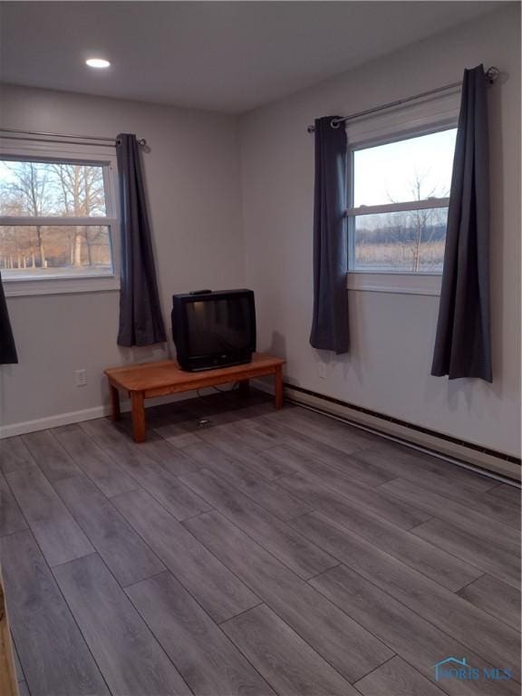 unfurnished room with a baseboard radiator and light hardwood / wood-style flooring