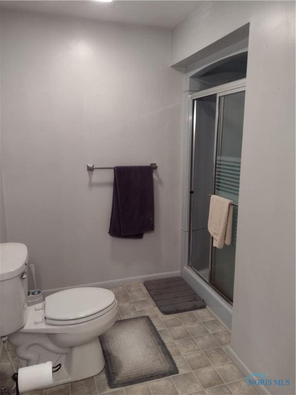 bathroom featuring toilet and an enclosed shower