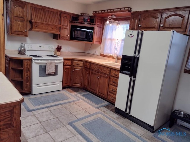 kitchen with sink, light tile patterned flooring, and white appliances