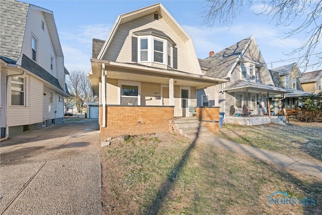 view of front facade with a porch, a garage, and an outdoor structure